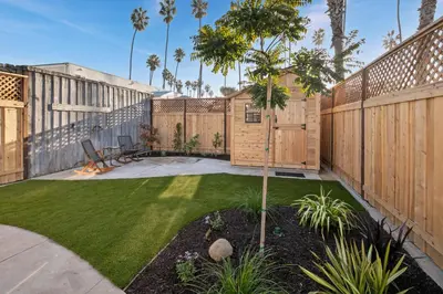 a backyard with a fence and a lawn at Surf Cottage 1 in San Diego