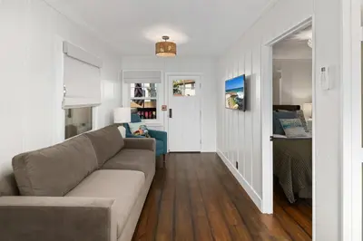 a living room with a couch and a bedroom at Surf Cottage 1 in San Diego