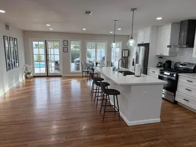 a kitchen with a large white island with bar stools at Heated pool, Sunny San Diego, Entire home, Free Parking, BBQ, Pets allowed, family neighborhood! in San Diego