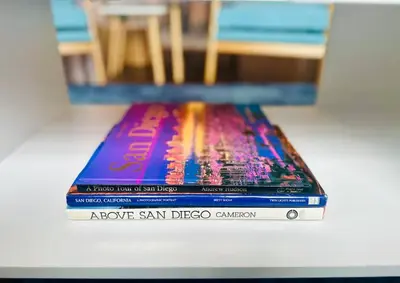 a stack of three books sitting on a table at 3-Bedroom, Prime Location, Private Backyard! in San Diego