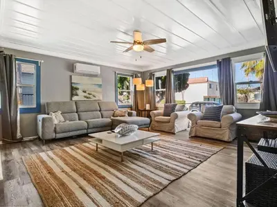 a living room with couches and a ceiling fan at Comfy Cottage Near the Beach in San Diego