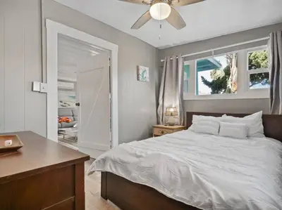 a bedroom with a bed and a ceiling fan at Comfy Cottage Near the Beach in San Diego