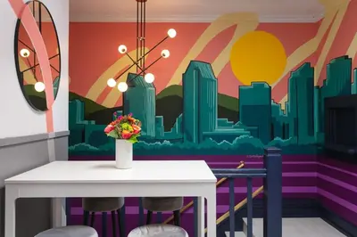 a dining room with a table and a city mural at La Ventana Hotel in San Diego