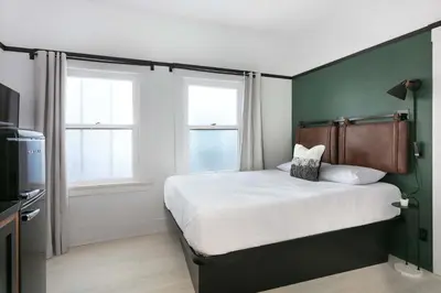 a bedroom with a bed with a green wall at La Ventana Hotel in San Diego