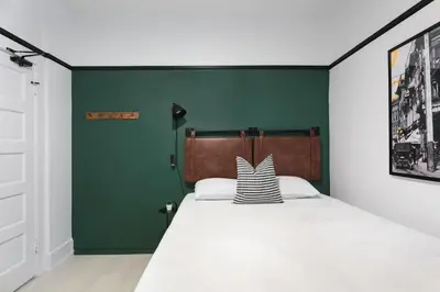 a bedroom with a bed with a green wall at La Ventana Hotel in San Diego