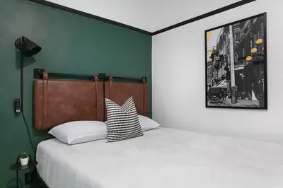 a bedroom with a bed with a black and white pillow at La Ventana Hotel in San Diego