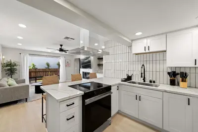a kitchen with white cabinets and a stove top oven at Stylish & Bright 5 Star Location Ocean View Queen Beds in San Diego