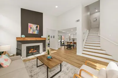 a living room with a fireplace and a staircase at Good Vibes Cottage - Carlsbad-Vista-San Diego-Beach-Legoland in Vista