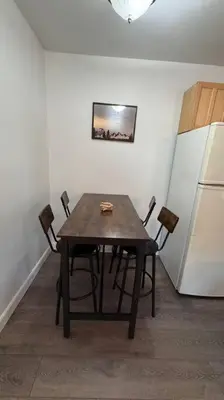 a dining room table with chairs and a white refrigerator at Cozy Mountain Guest house in Pine Valley