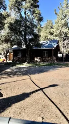 a house with a tree in front of a street at Cozy Mountain Guest house in Pine Valley