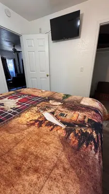 a bedroom with a bed with a tv on the wall at Cozy Mountain Guest house in Pine Valley