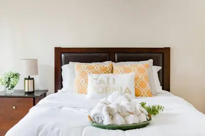 a bed with pillows and a tray of towels at Creative Haven Chic 3-Bedroom with Artistic Touches in San Diego