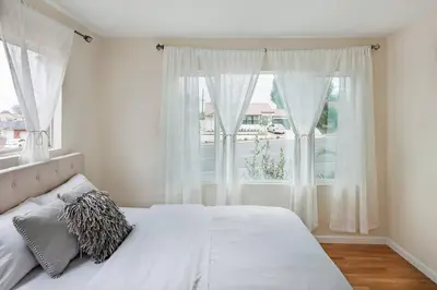 a bedroom with a white bed and a window at Creative Haven Chic 3-Bedroom with Artistic Touches in San Diego