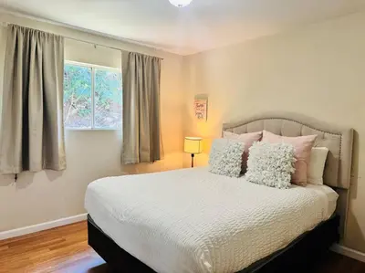 a bedroom with a bed with pillows and a window at Creative Haven Chic 3-Bedroom with Artistic Touches in San Diego