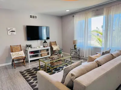 a living room with a couch and a flat screen tv at Creative Haven Chic 3-Bedroom with Artistic Touches in San Diego