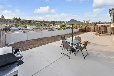 a patio with a table and chairs and an umbrella at Hilltop Home Hot Tub BBQ Game Room Self Check-In in Poway