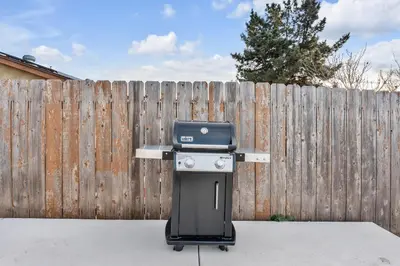 a bbq grill sitting in front of a fence at Hilltop Home Hot Tub BBQ Game Room Self Check-In in Poway