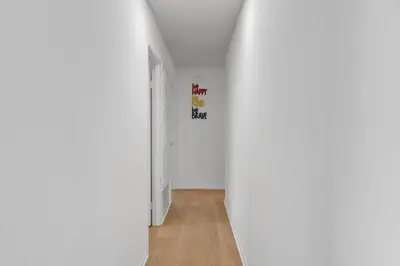 an empty hallway with a white room with a sign on the wall at Hilltop Home Hot Tub BBQ Game Room Self Check-In in Poway