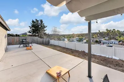 a backyard with a wooden deck with a fence at Hilltop Home Hot Tub BBQ Game Room Self Check-In in Poway