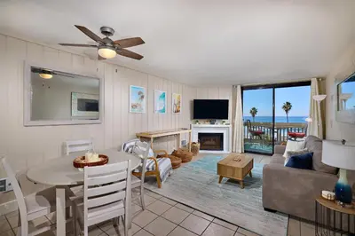 a living room with a table and a living room with a television at Oceanside Beach Condos in Oceanside