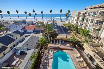 an aerial view of a resort with a swimming pool and the beach at Oceanside Beach Condos in Oceanside