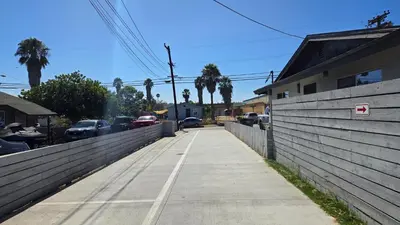 a sidewalk next to a fence with cars parked at Exotic home Sdstay-com in Spring Valley