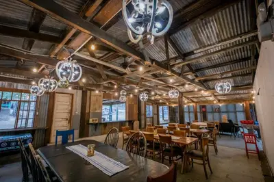 a dining room with tables and chairs and chandeliers at Historic Farmhouse on 5 Peaceful Acres with Ancient Oaks & Creek above Temecula in Temecula