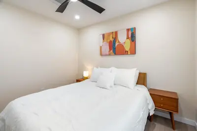 a bedroom with a white bed and a painting at Urban Oasis - Just Remodeled in San Diego