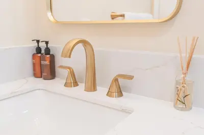 a bathroom sink with a gold faucet and a mirror at Urban Oasis - Just Remodeled in San Diego