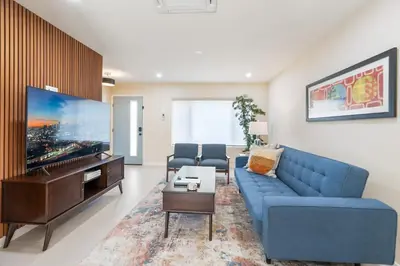 a living room with a blue couch and a flat screen tv at Urban Oasis - Just Remodeled in San Diego