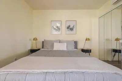 a large white bed in a white room with two lamps at Resort Living with Pool & Tennis Minutes to Del Mar Beaches in San Diego