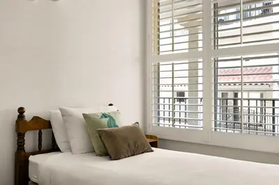 a bedroom with a bed with white sheets and a window at Waterfront Condo Unmatched Views and Prime Location in San Diego