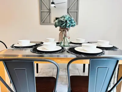 a table with plates and cups on top of it at Pet friendly Spacious 3Bed with HUGE Back Yard in San Diego