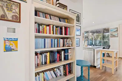 a book shelf filled with books next to a kitchen at Del Mar Deluxe Palace - Majestic - Iconic- Retreat in San Diego