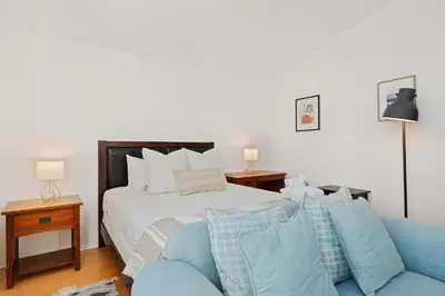 a bedroom with a bed and a blue couch at Del Mar Deluxe Palace - Majestic - Iconic- Retreat in San Diego