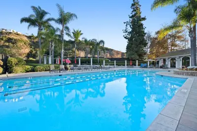 a swimming pool with blue water and palm trees at Del Mar Deluxe Palace - Majestic - Iconic- Retreat in San Diego