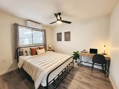 a bedroom with a bed and a desk and a window at Comfortable 2Bed in Duplex with private Sunroom in San Diego
