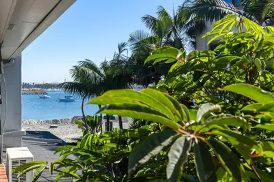 a view of a beach with a boat in the water at Bayfront Apartment Steps to the Sand - Ultimate Coastal Living in San Diego