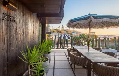 a restaurant with a table and chairs and an umbrella at Nord Moonlight Beach Luxury Home in Encinitas