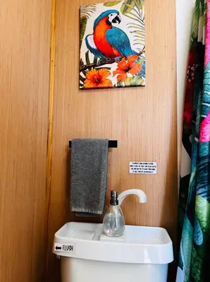 a bathroom with a toilet with a bird picture on the wall at Bird of Paradise Retreat with stunning mountain views in El Cajon