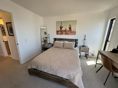 a bedroom with a large bed and a desk at Penthouse at Pacific Beach Crystal Pier in San Diego