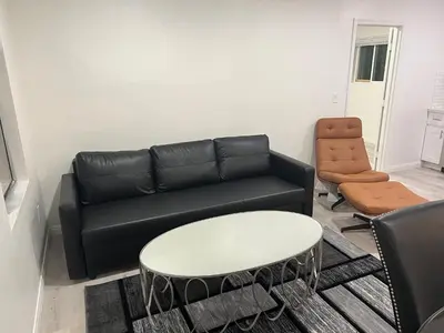 a living room with a black couch and a table at Modern and charming 1 bed first floor apartment in La Mesa
