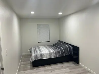 a bedroom with a bed in the corner of a room at Modern and charming 1 bed first floor apartment in La Mesa