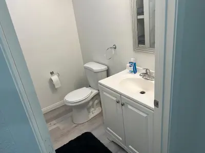 a white bathroom with a toilet and a sink at Modern and charming 1 bed first floor apartment in La Mesa