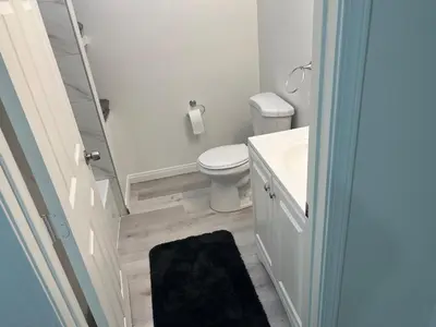 a white bathroom with a toilet and a sink at Modern and charming 1 bed first floor apartment in La Mesa