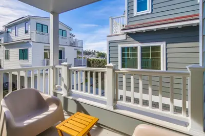a porch with a white railing and a chair at The Shores 8 in San Diego