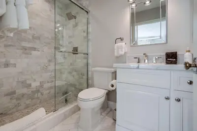 a bathroom with a toilet and a glass shower at The Shores 8 in San Diego