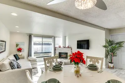 a living room with a table and a fireplace at Waterfront Condo with Dock Access in Carlsbad! in Carlsbad