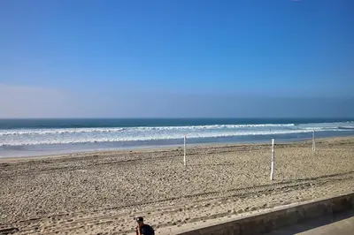 a man walking on the beach near the ocean at Ocean Front Walk in San Diego