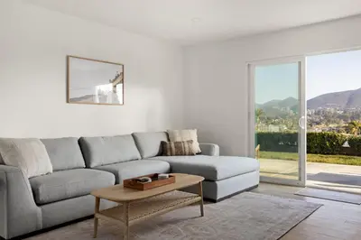 a living room with a couch and a table at Modern Escape w Mountain Views, Walk to Lake, Golf, Resort, Dining in San Marcos